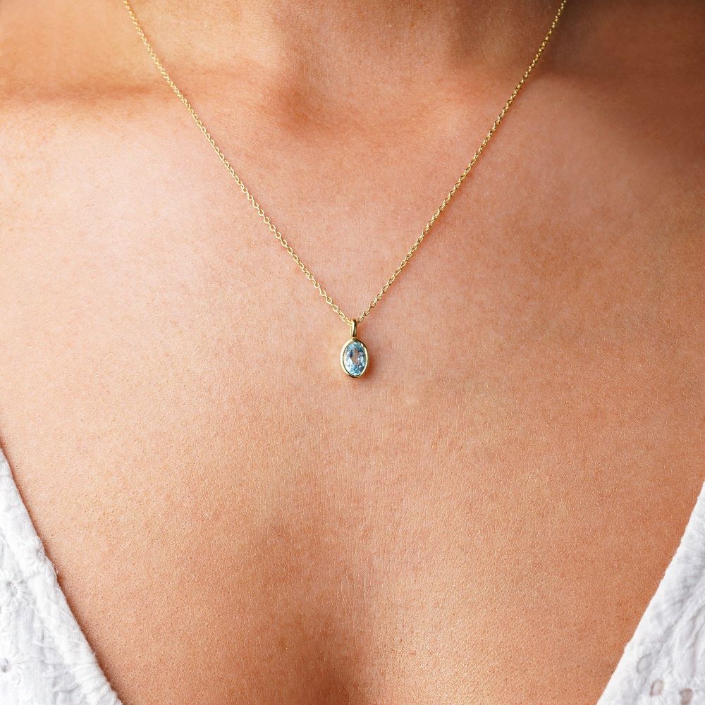 Blauwe Topaas edelsteen ketting in goud. Kristallen sieraden met blauwe topaas, de geboortesteen van december.