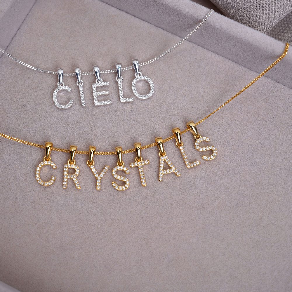 Kristallen bedels met letters in zilver en goud. Lettersieradencollectie met echte kristallen.