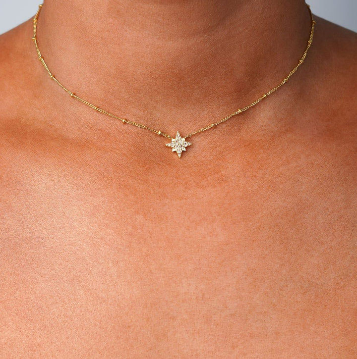 Gouden ketting met ster van White Topaas kristallen. Sterrenketting van goud en echte edelstenen.