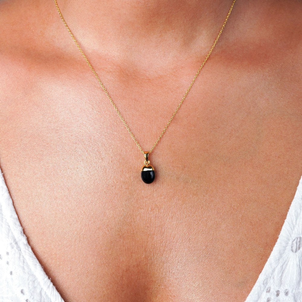 Sieraden met Onyx in goud om als ketting te dragen, Kristallen sieraden met zwarte onyx, de geboortesteen van juli.